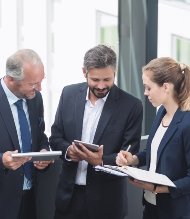Three business professionals standing and having a conversation